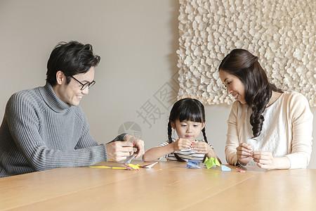 一家三口坐在桌前玩亲子游戏图片素材